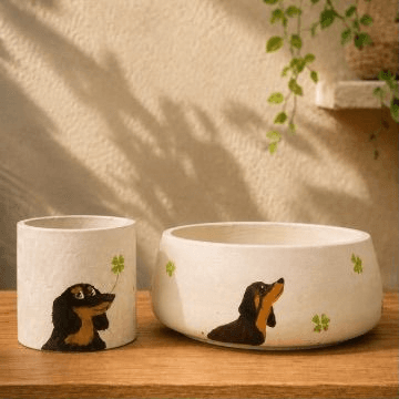 Planter set painted with a black and tan dachshund reaching for a clover