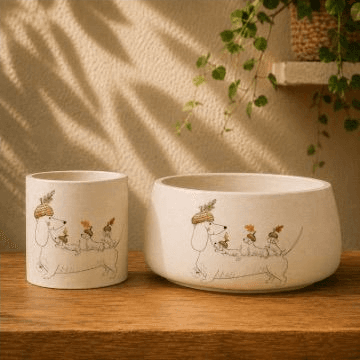 Planter set with a line-drawn parade of three dachshunds in hats